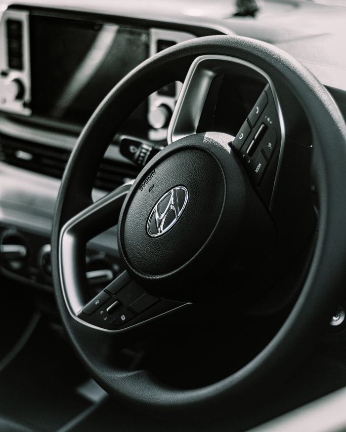 The Art of Drawing Readers In: Your attractive post title goes here Detailed view of a vehicle's steering wheel with dashboard features, perfect for automotive themes.